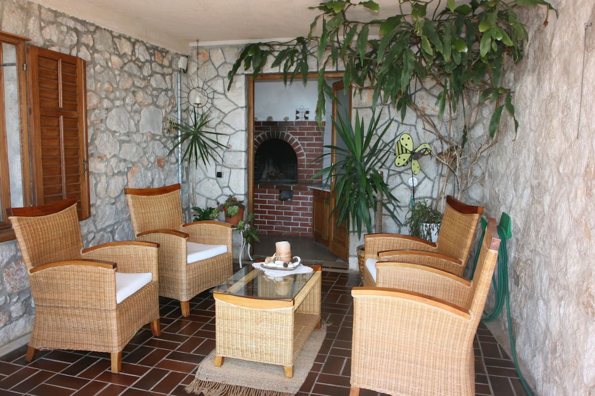 A cozy living area with wicker furniture, a glass coffee table, and a brick fireplace.