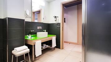 Ein modernes Badezimmer mit einem grünen Waschtisch, einer weißen Toilette und einer Duschkabine aus Glas.