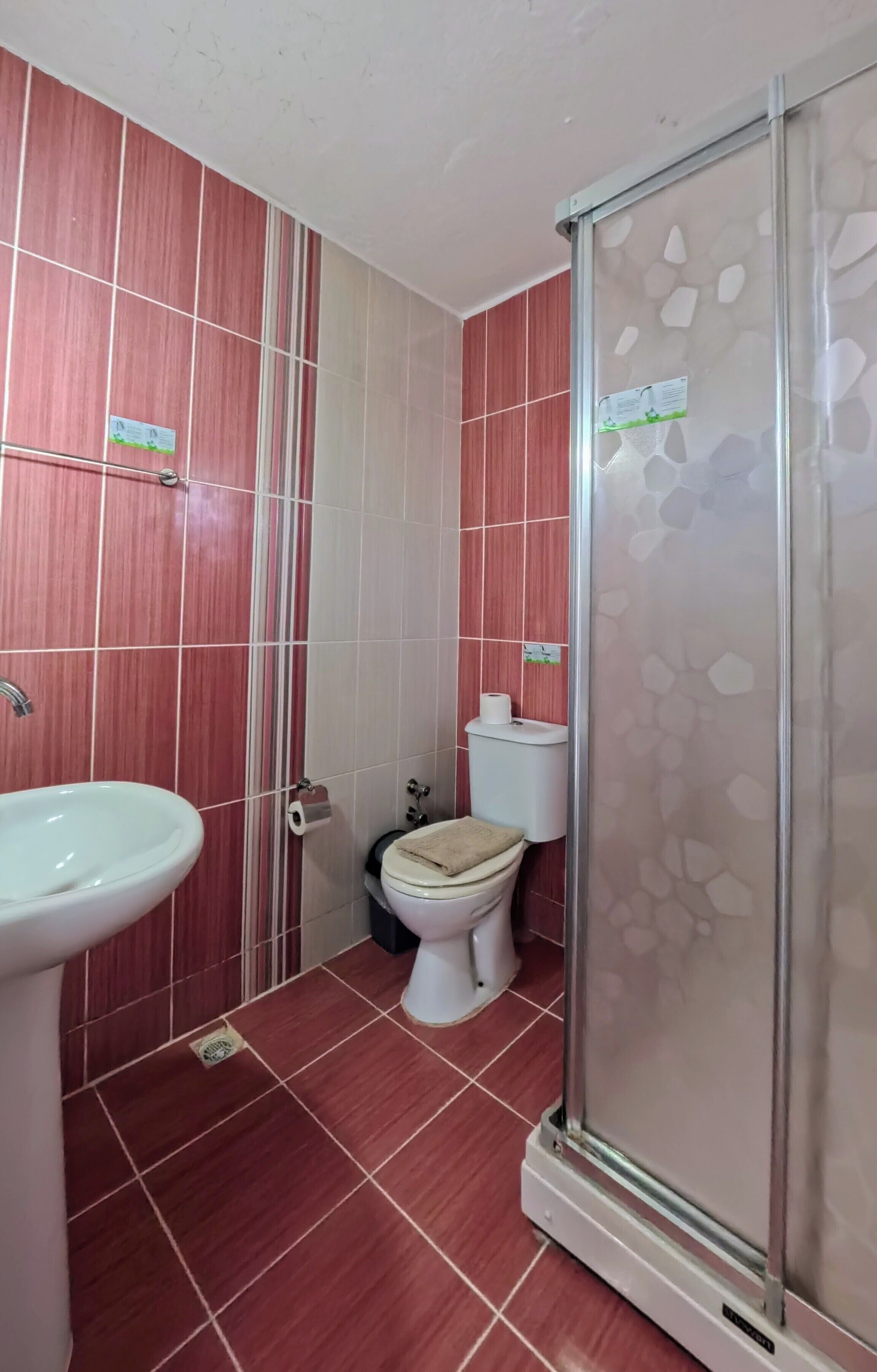 Un baño con ducha, inodoro y lavamanos.
