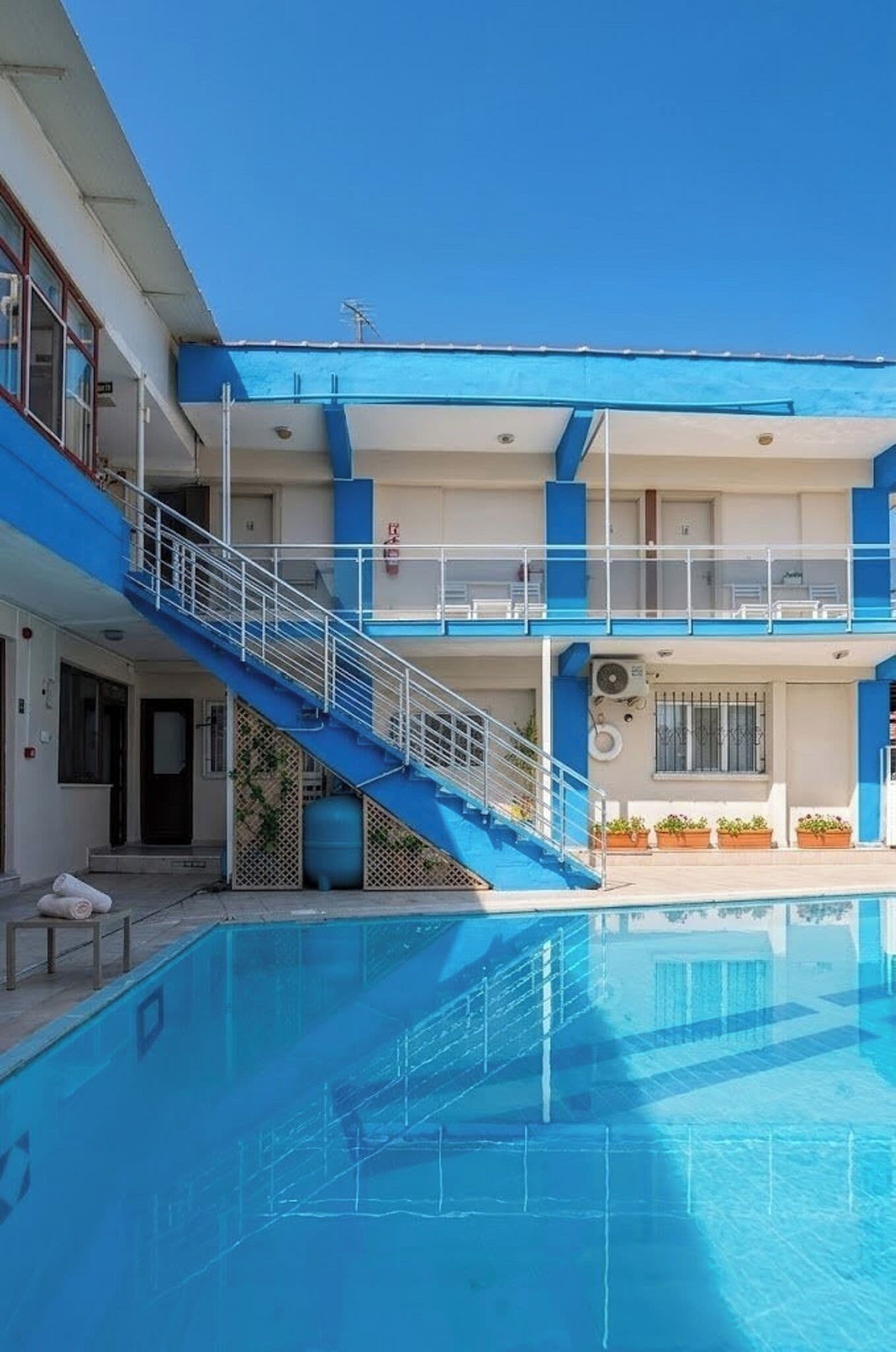 Ein Hotel mit Schwimmbad, Treppe und Balkonen.