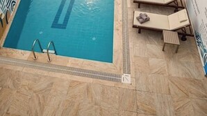 A swimming pool with a reception area and lounge chairs. - Aspawa Hotel (Denizli)