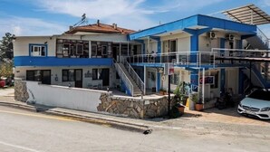 A two-story building with a blue and white exterior, a stone facade, and a staircase leading to the upper level. - Aspawa Hotel (Denizli)