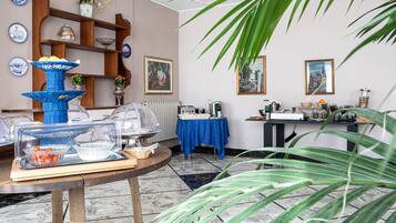 Una stanza con un angolo buffet, un tavolo con tovaglia blu e una mensola con oggetti decorativi.