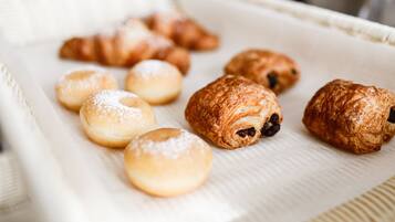 A tray of assorted pastries including croissants and doughnuts.