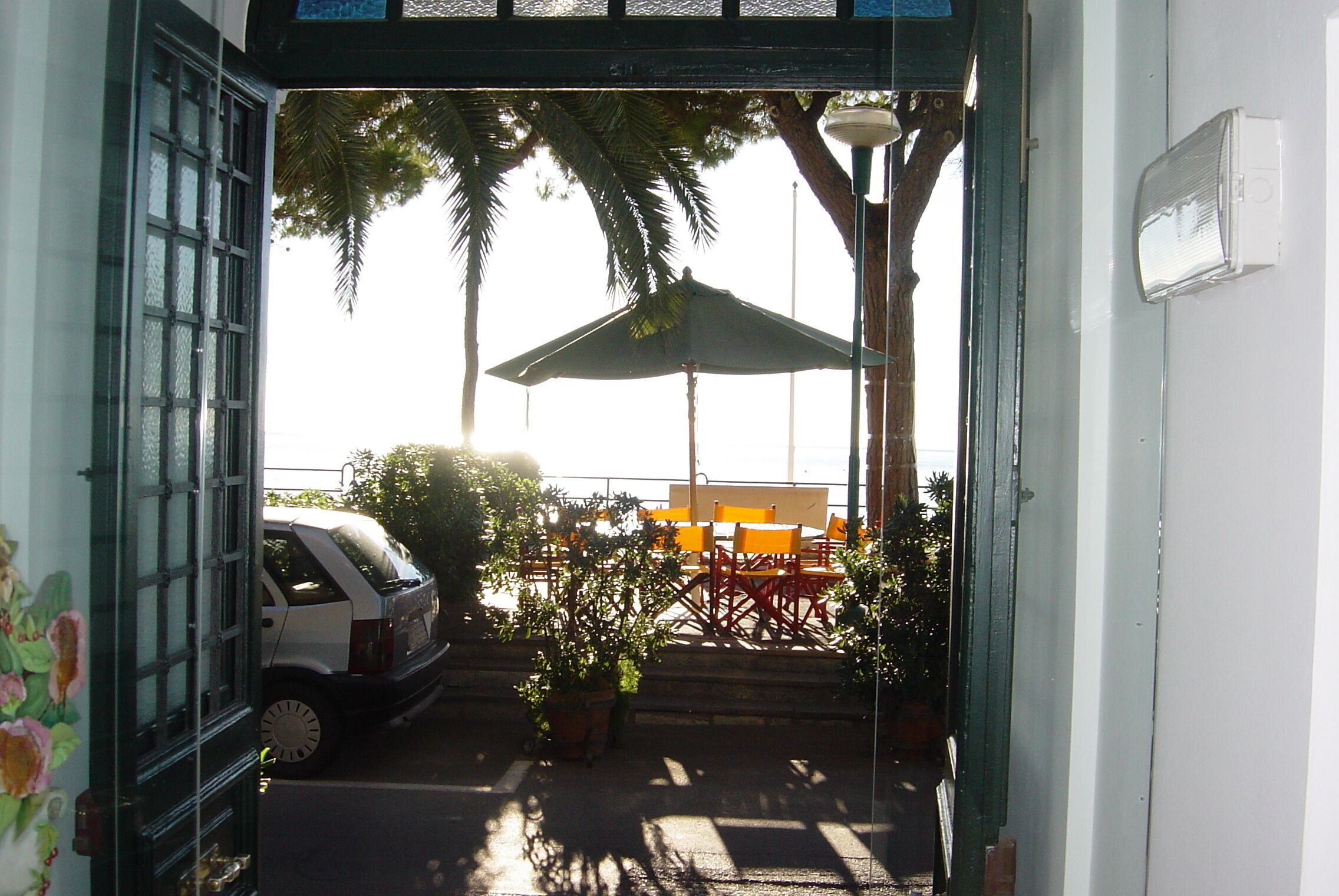 A covered outdoor seating area with a car parked nearby.