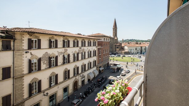 A view of a street with buildings, a church tower, and a clear sky. - Maison de Charme (Florence)