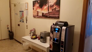 A hotel room with a coffee machine, a map, a trash bin, and a poster of a cityscape. - Maison de Charme (Florence)