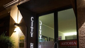 The exterior of City Hotel with a prominent entrance, a signboard, and a potted plant. - Hotel Astoria (Cremona)