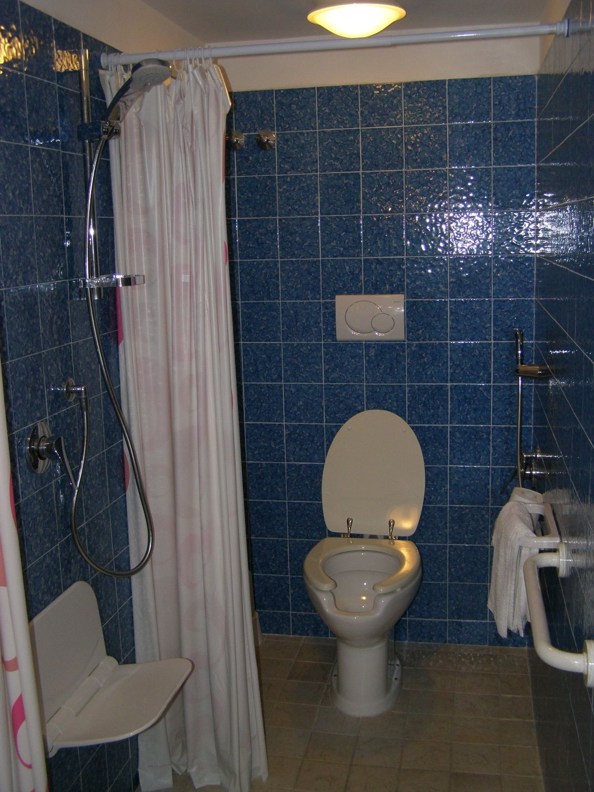 A bathroom with a shower, toilet, and a sink.