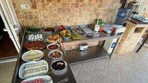 A buffet with various food items including sliced tomatoes, cucumbers, and meats. - Rebetika Hotel (Selçuk)