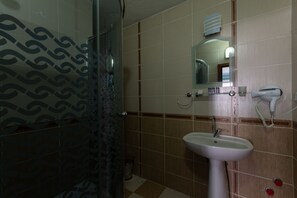 Habitación triple | Baño | Ducha, artículos de higiene personal gratuitos y secador de pelo