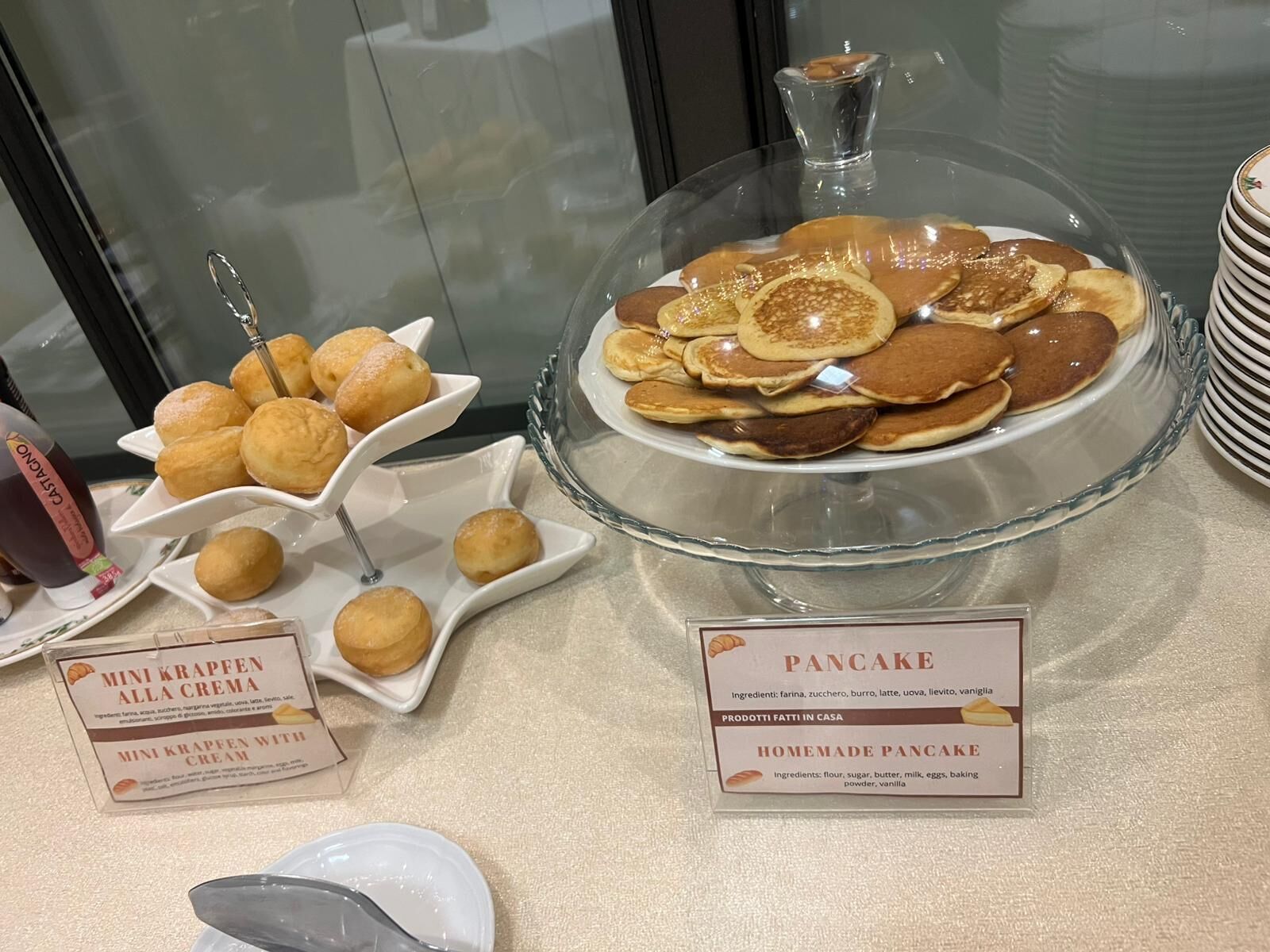 A breakfast buffet with mini krappfen alla crema and homemade pancakes.