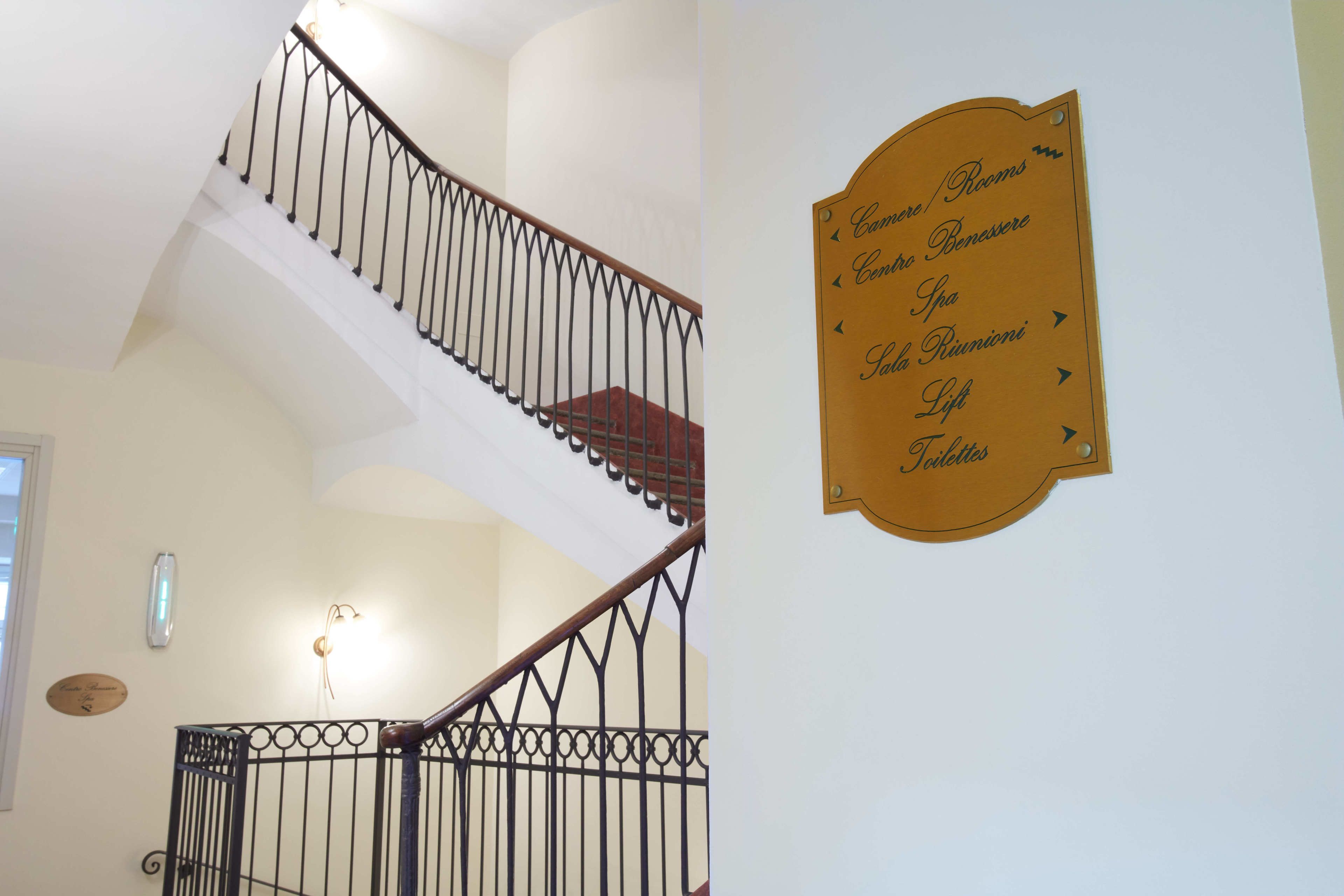 Una scala con un cartello che indica i tipi di camere e i servizi offerti.