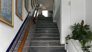 A staircase with a tiled handrail and a potted plant on the right. - Hostal San Felipe (Marbella)