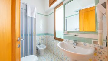 Un baño con inodoro, bidé y lavabo.