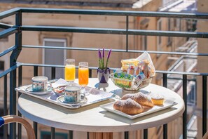 A balcony with breakfast items including pastries, juice, and a fruit basket. - La Casa delle Stelle (Maiori)