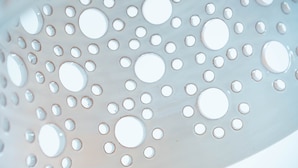 A close-up of a perforated metal surface with circular holes. - La Casa delle Stelle (Maiori)