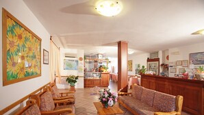 Eine Hotelhalle mit Holzmöbeln, einer Rezeption und einem Essbereich.