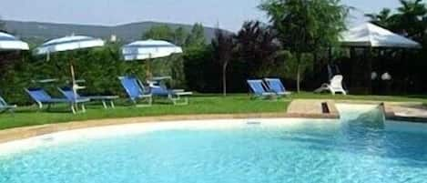 Piscine extérieure, parasols de plage, chaises longues