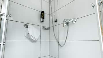 A modern shower with a handheld showerhead and a handheld faucet.