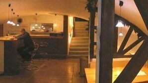 Un interior moderno con una zona de bar, una escalera y un área de estar.