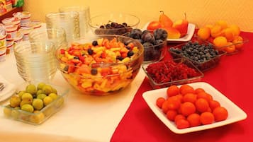 A buffet table with various fruits and bowls of food.