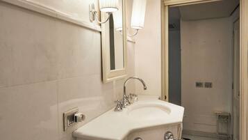 A bathroom with a white sink, a mirror, and a towel rack.