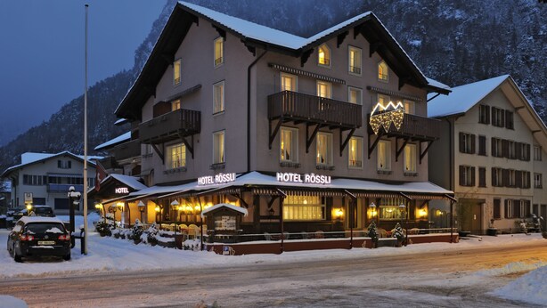 A hotel with a traditional Alpine architectural style, featuring balconies and a snow-covered landscape. - Hotel Rössli (Unterseen)