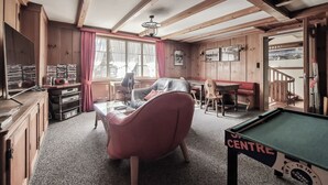 A cozy room with a pool table, a leather chair, a desk with a computer, and a window with curtains. - Hotel Rössli (Unterseen)