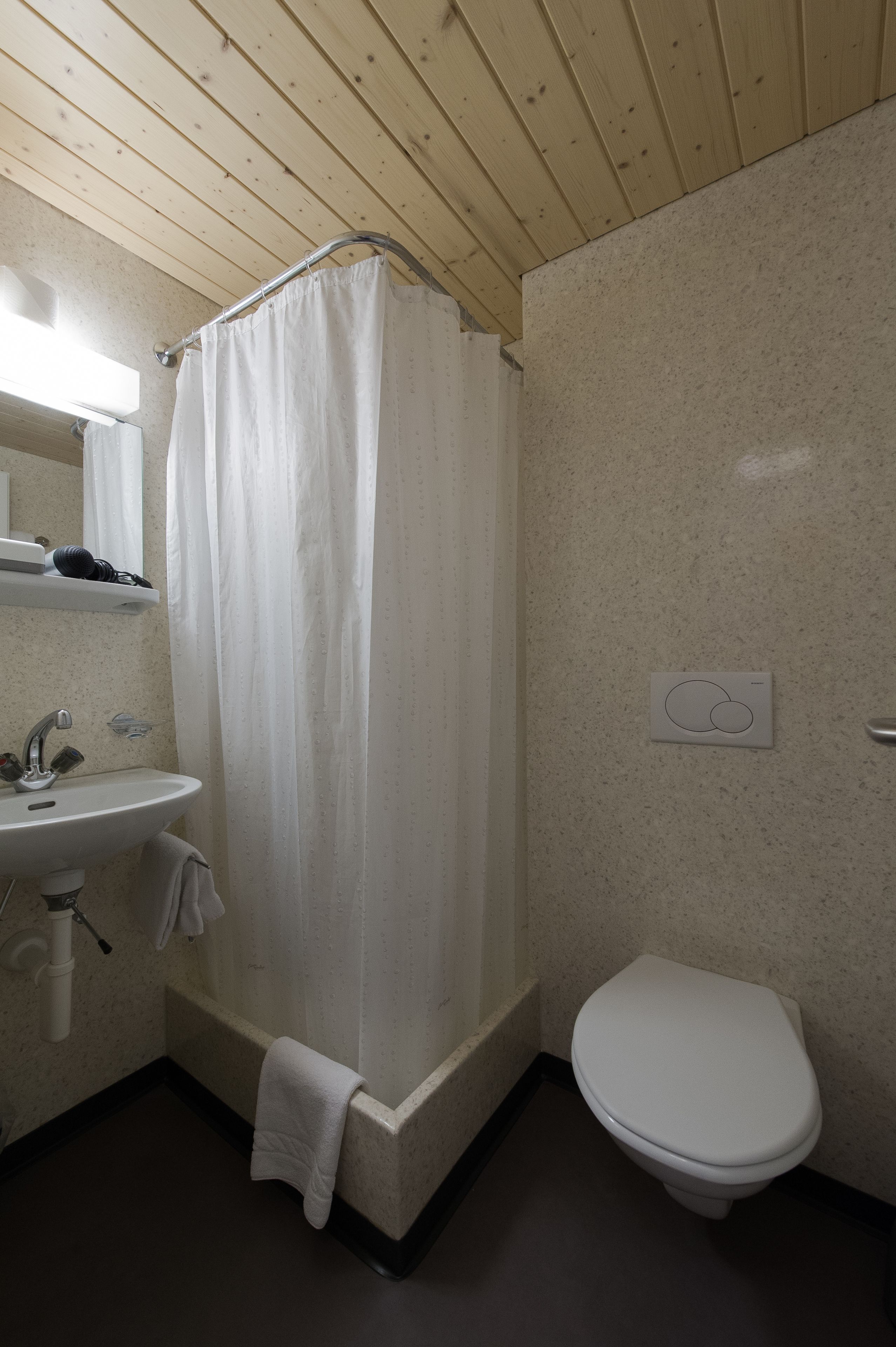 Ein Badezimmer mit Duschvorhang, Waschbecken und Toilette.