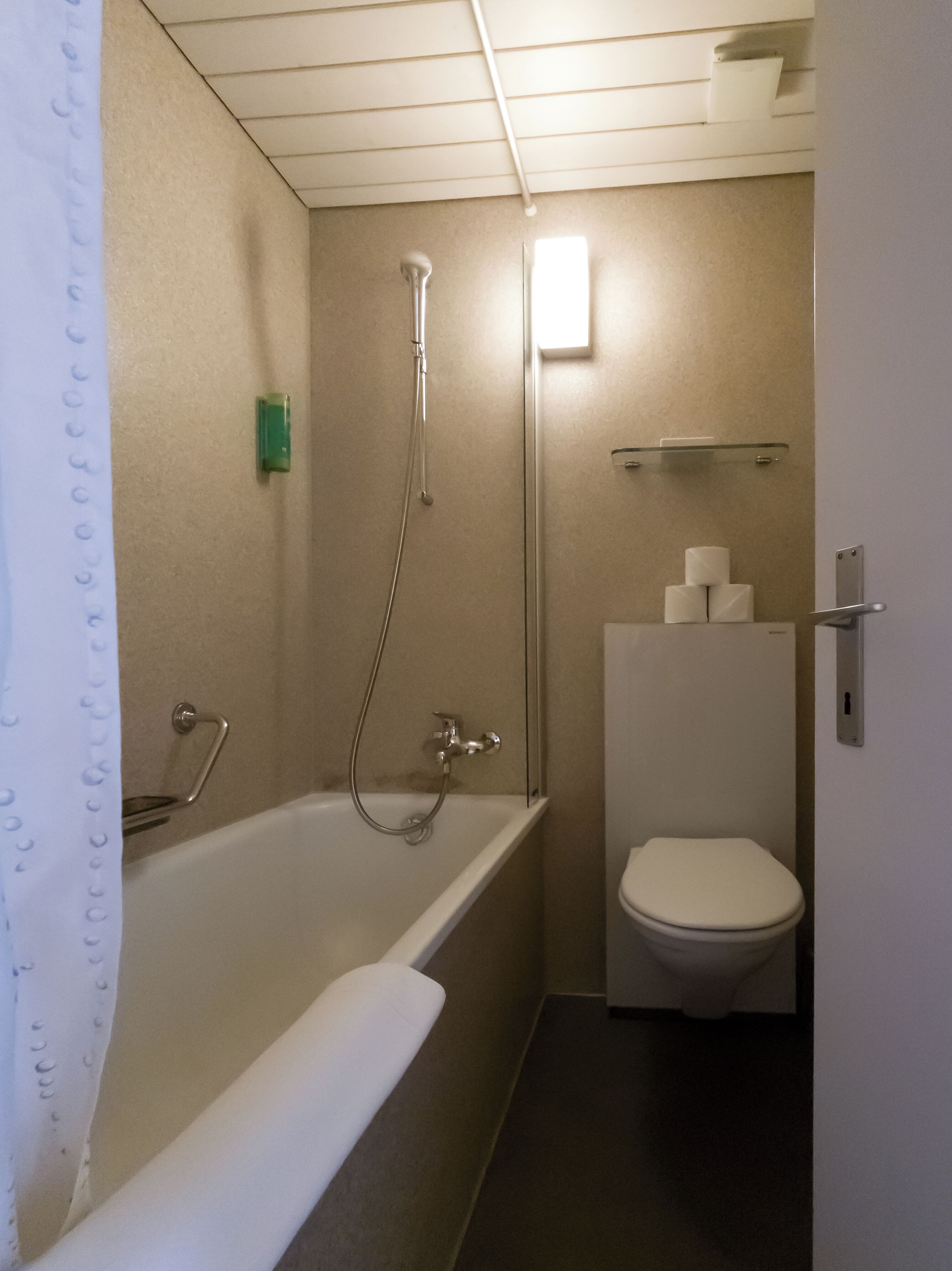 Un baño con bañera, inodoro y ducha.