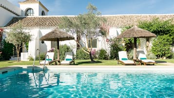 Una piscina al aire libre de temporada, sillones reclinables de piscina