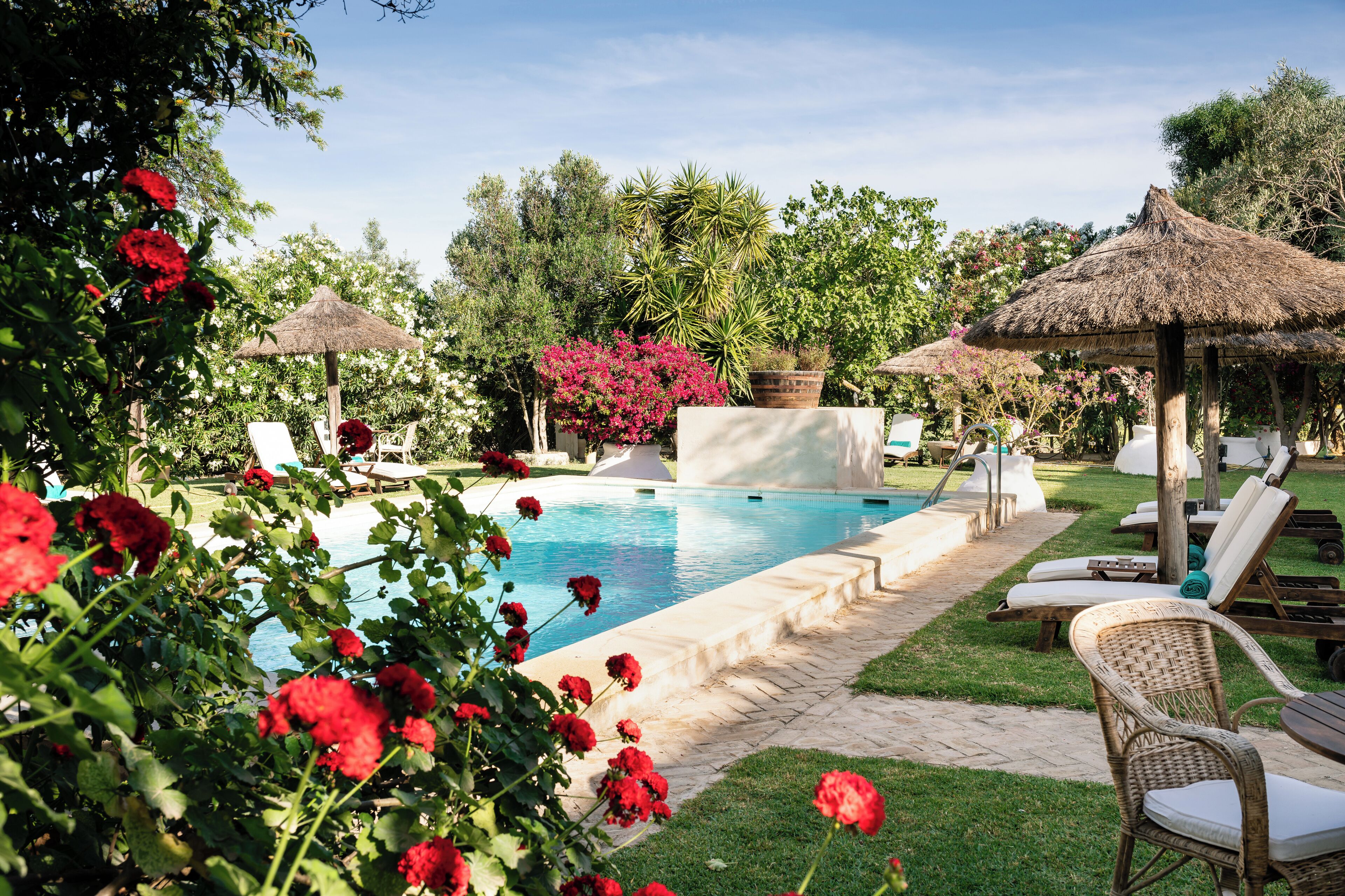 Een seizoensgebonden buitenzwembad, ligstoelen bij het zwembad