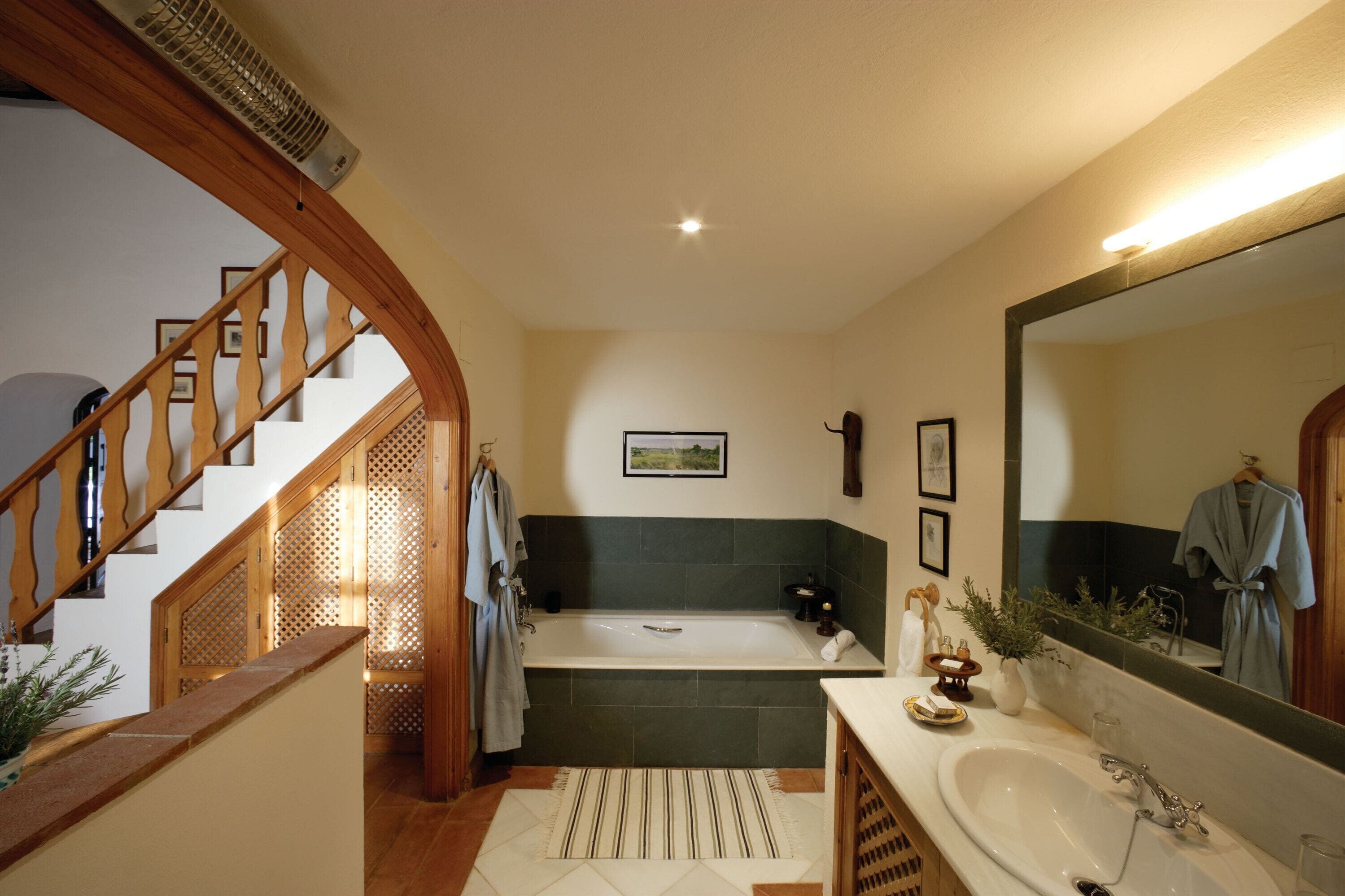 A bathroom with a bathtub, sink, and mirror.