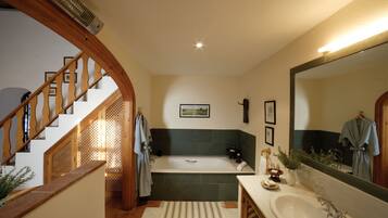 A bathroom with a bathtub, sink, and mirror.