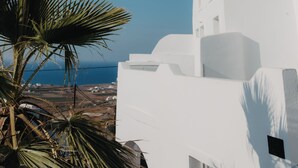 A white building with a curved roof and a clear blue sky.