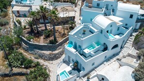 A white building with multiple balconies and a swimming pool.