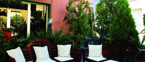 A hotel named "HOTEL TARCONTE" with outdoor seating and a large sign.