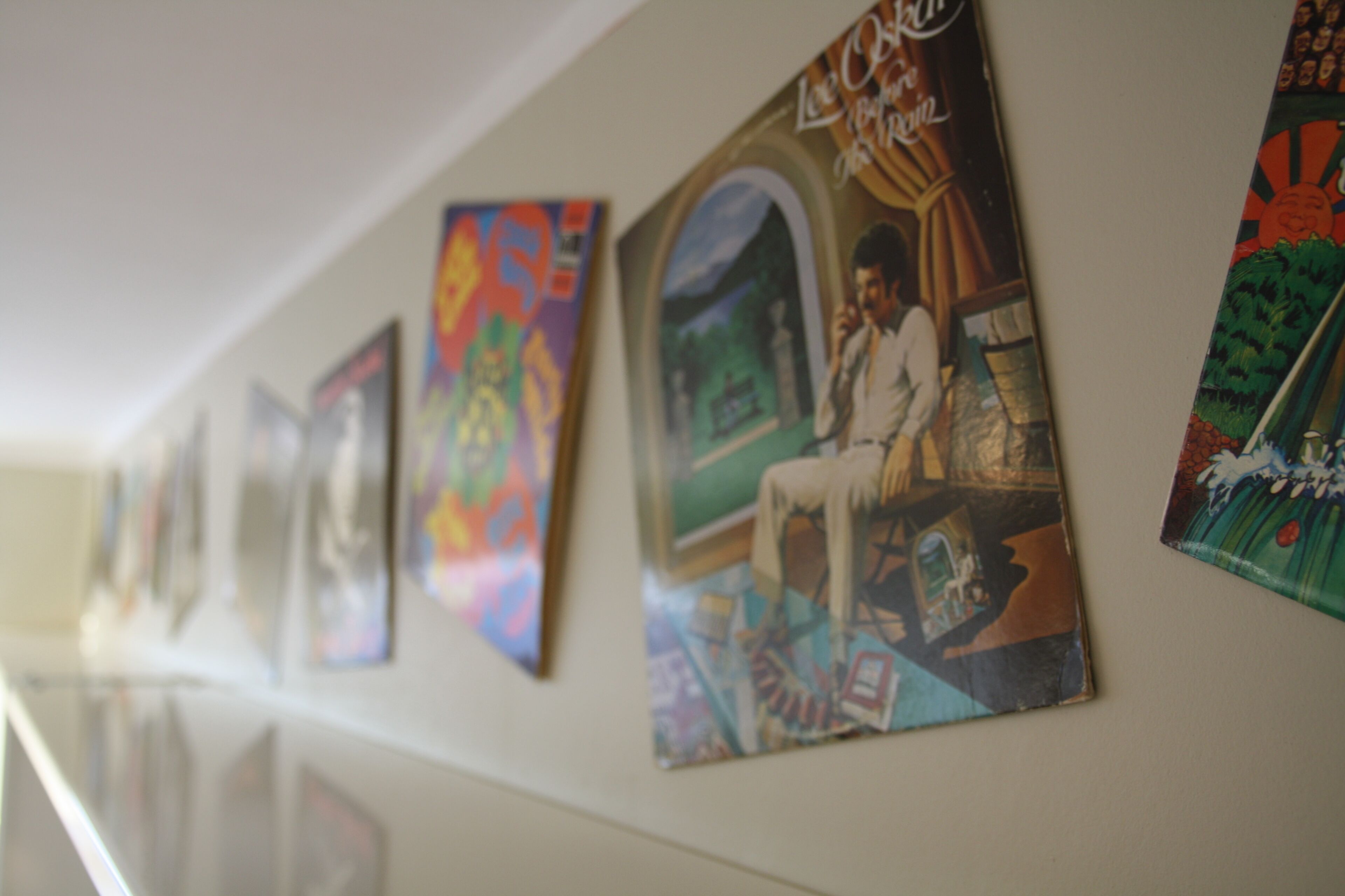 A wall with a series of framed artworks.