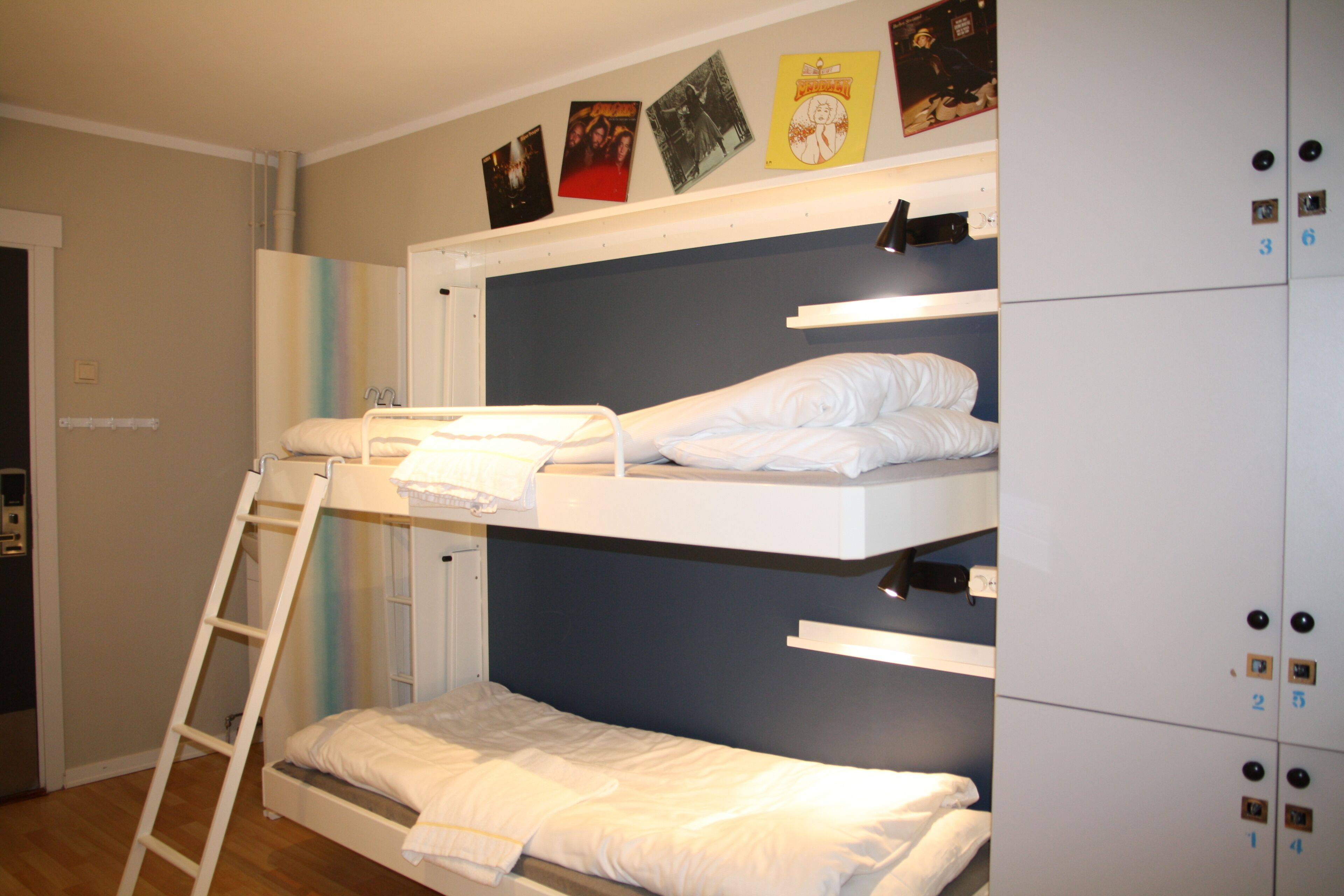 Habitación con literas, un armario y una estantería con fotografías.