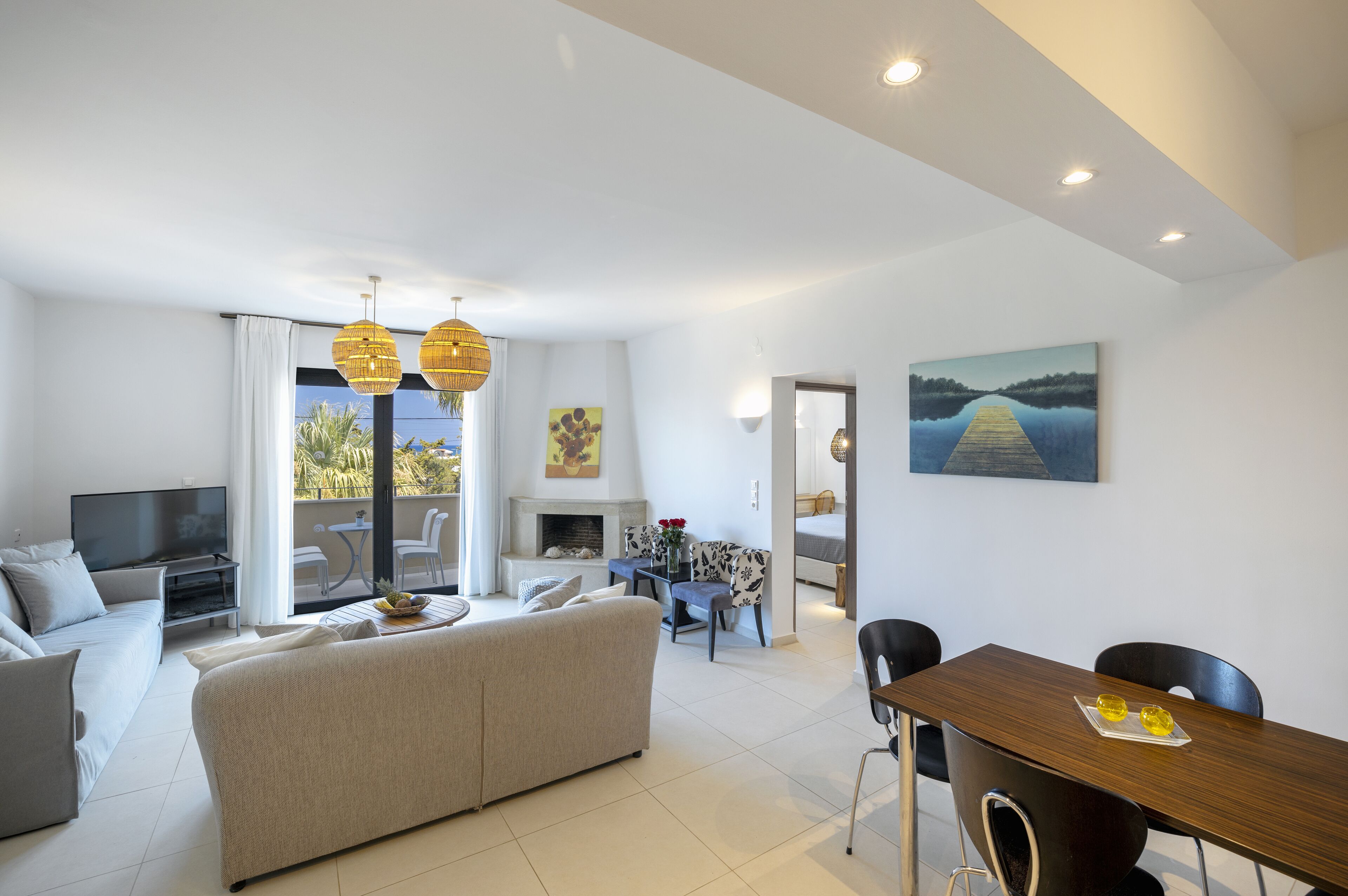 A modern living room with a sofa, TV, and dining area with chairs and a table.
