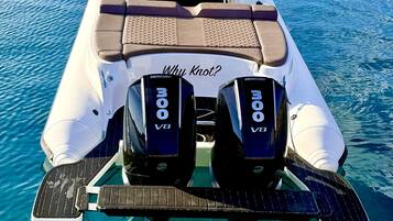 Un bateau équipé de deux moteurs Mercury V8, d’un espace salon avec des coussins et d’une pancarte sur laquelle on peut lire « Why Knot? »