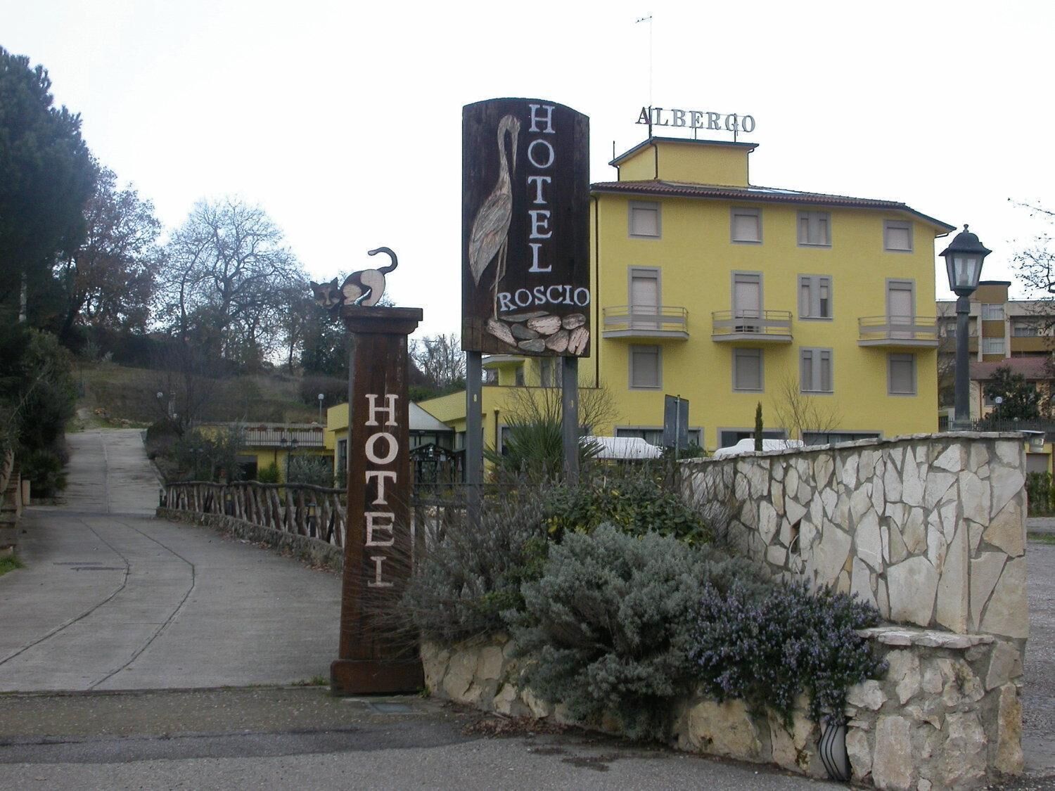 A hotel entrance with a sign reading "Hotel Roscio" and "Albergo".