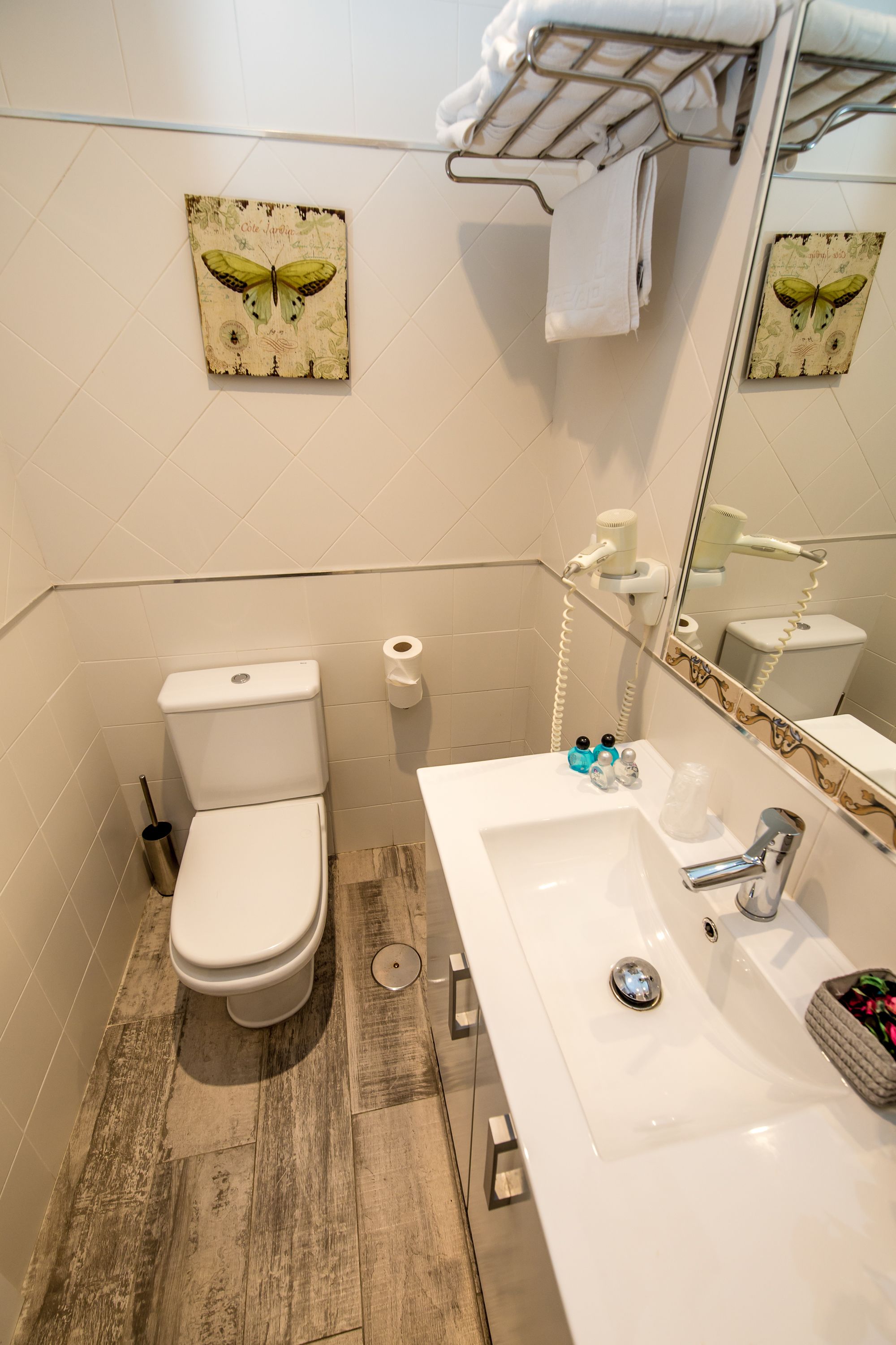 A bathroom with a toilet, sink, and a towel rack.