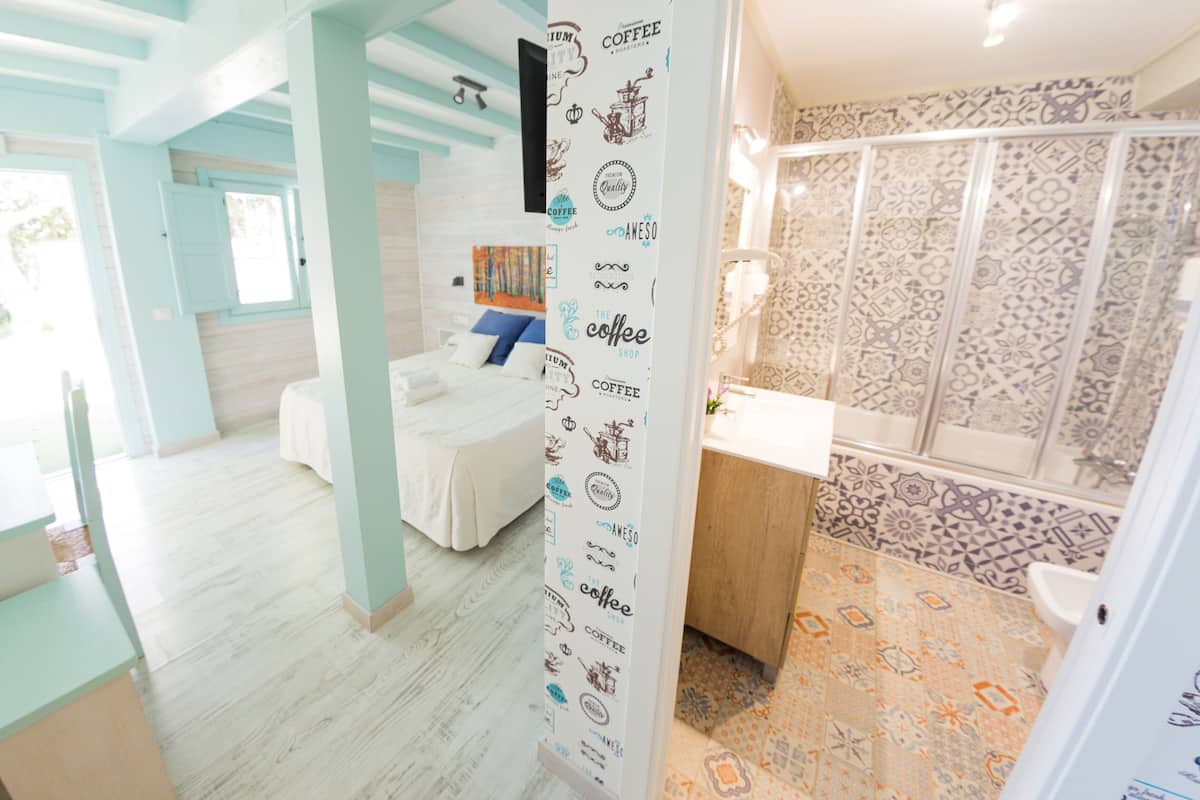 Une chambre d’hôtel équipée d’un lit, d’un bureau et d’un espace douche.