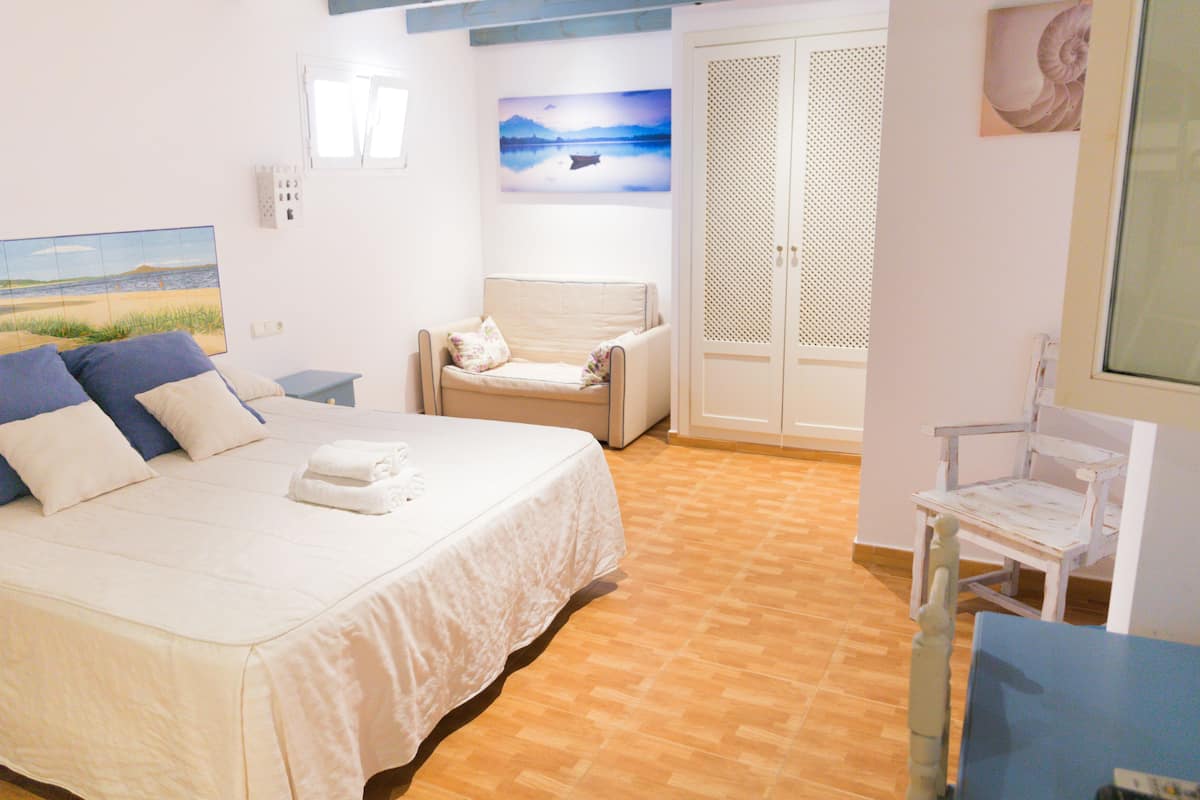 Une chambre à coucher avec un lit, une chaise, un bureau et une armoire.