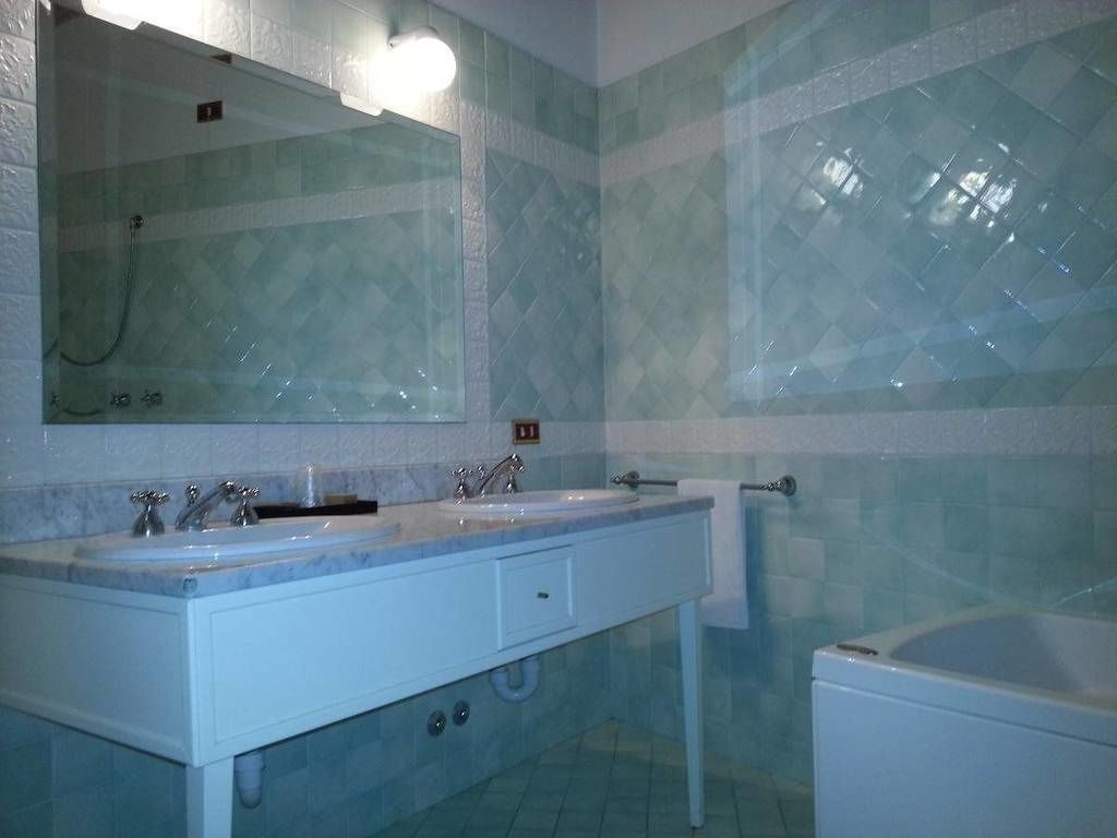 Un baño con dos lavamanos, un espejo y una bañera.