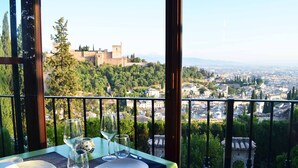A table set for two with a view of a historic castle and cityscape. - Santa Isabel la Real Hotel (Granada)