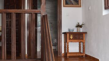 A wooden staircase with a small table and a framed painting on the wall.