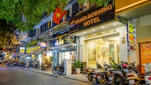 A street view of Hanoi Morning Hotel with multiple motorcycles parked in front. - Hanoi Morning Hotel (Hanoi)